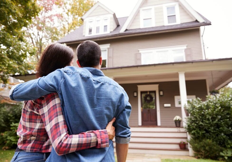 Rear View Of Loving Couple Looking At House